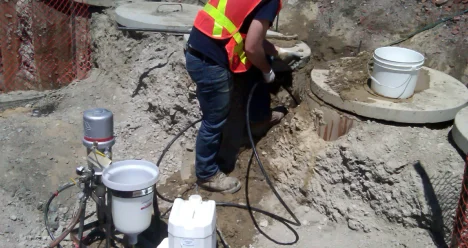 Worker using equipment at construction excavation site.