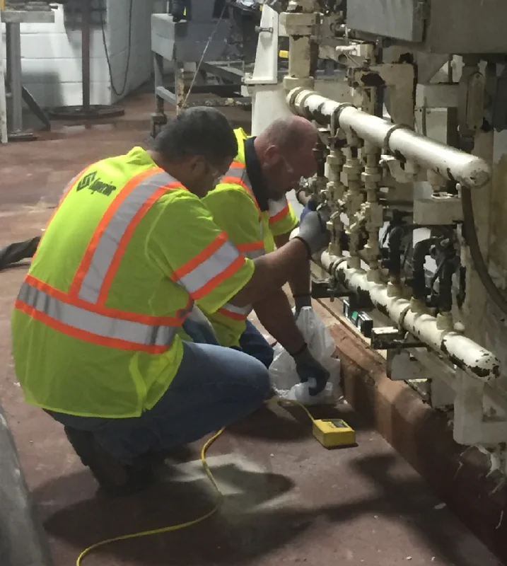 Workers in reflective vests repairing machinery