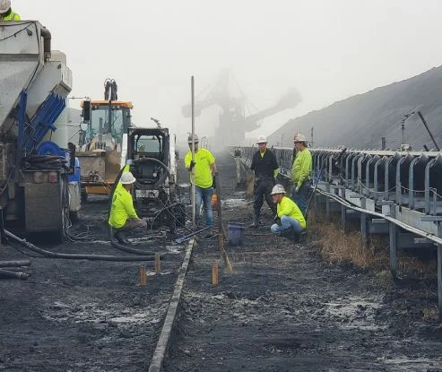 Workers and machinery at industrial construction site.