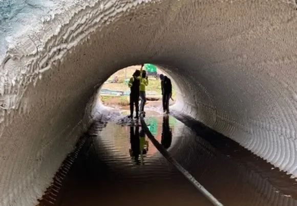 People walking through a water-filled tunnel.