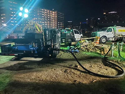 Nighttime construction site with worker and machinery.