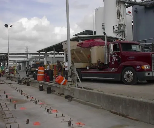 Construction site with workers and red truck.