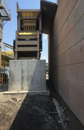 Industrial site with concrete block near building entrance.