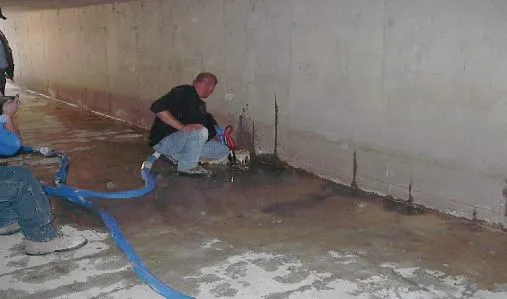 Man performing water extraction from flooded basement.