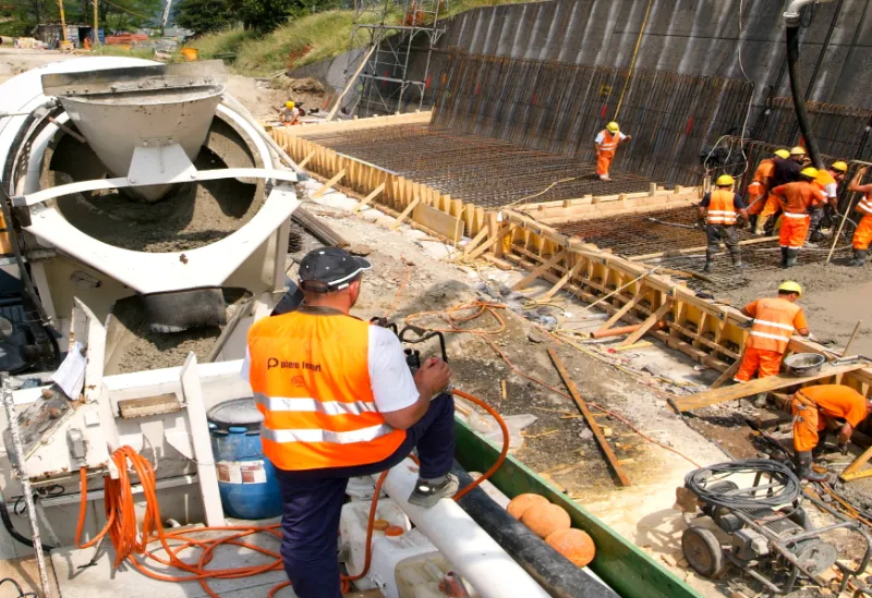 Construction workers pouring concrete at a building site.