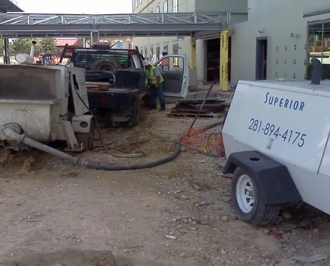 Construction workers and equipment at building site.