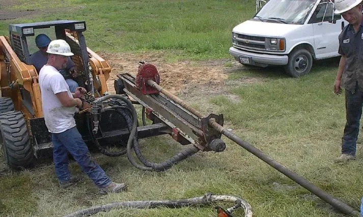 Workers using heavy machinery for construction outdoors.