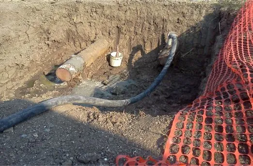 Underground pipe excavation with safety netting.