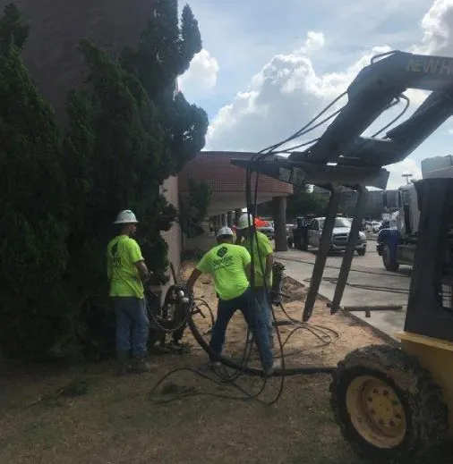 Workers operating machinery for landscaping maintenance.