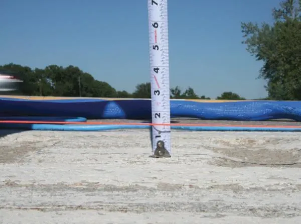 Measuring tape showing depth of sandbox outdoors.