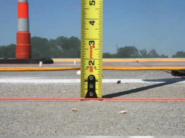 Measuring road surface with tape measure.