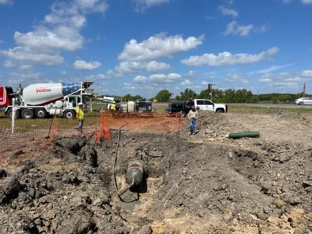 Construction site with workers and concrete mixer truck.