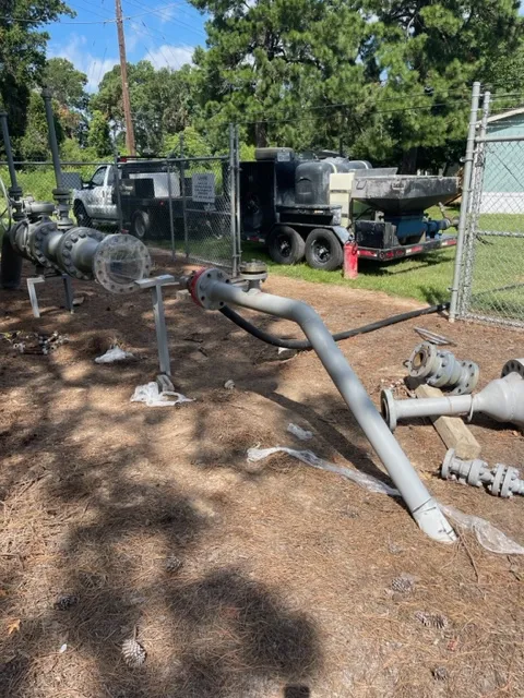 Disassembled industrial pipes in outdoor storage area.