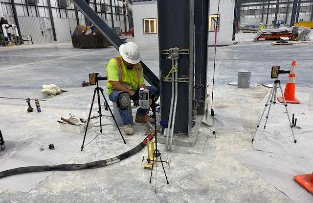 Worker using tools at construction site.
