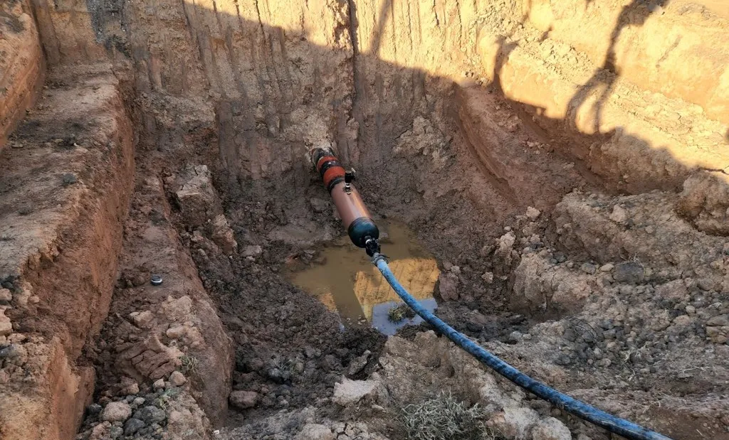 Underground pipe installation in excavated trench.