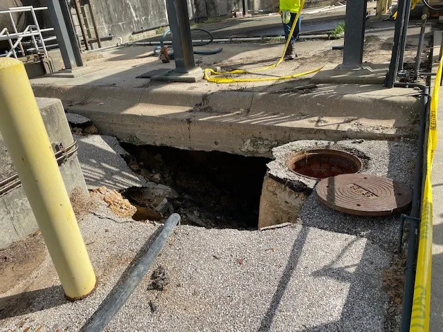 Collapsed concrete sidewalk with exposed underground area.