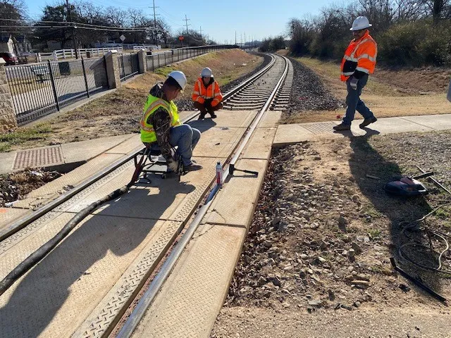 Workers inspecting railroad tracks during maintenance.