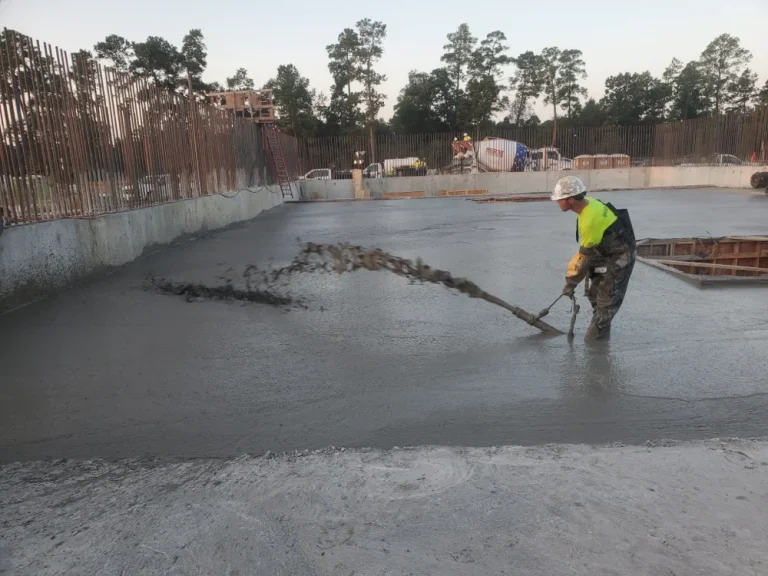 Worker pouring concrete at construction site