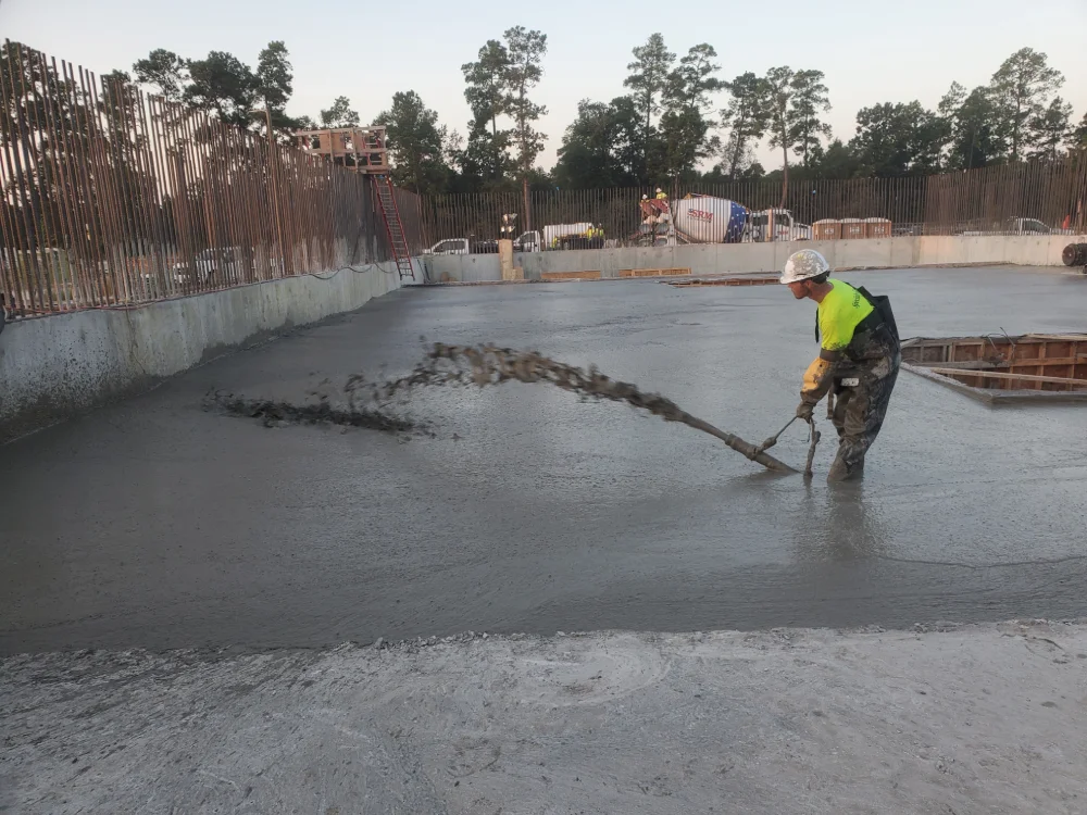 Worker pouring concrete at construction site